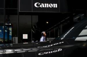 A man walks past a showroom of Japanese imaging and optical products manufacturer Canon in Tokyo